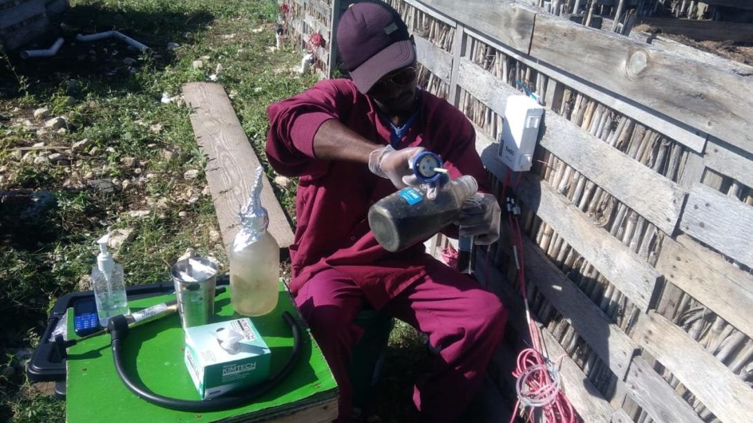 SOIL intern, Wenley Moïse, extracting samples from the liquid filters installed underneath SOIL's composting bins to take to the lab for testing.